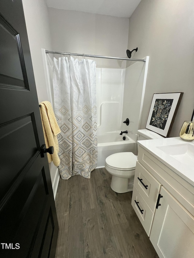 bathroom featuring toilet, shower / bath combo with shower curtain, wood finished floors, and vanity