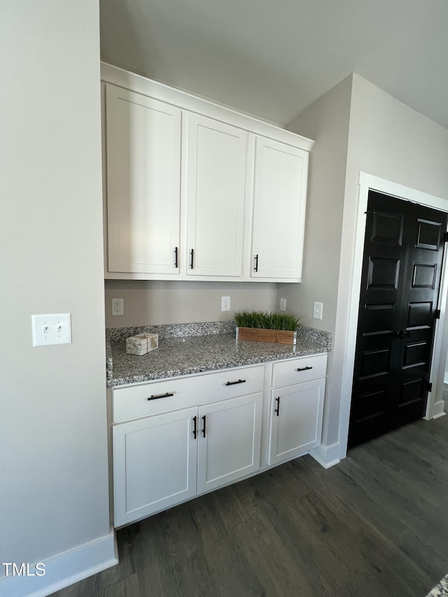 bar featuring dark wood-style floors and baseboards