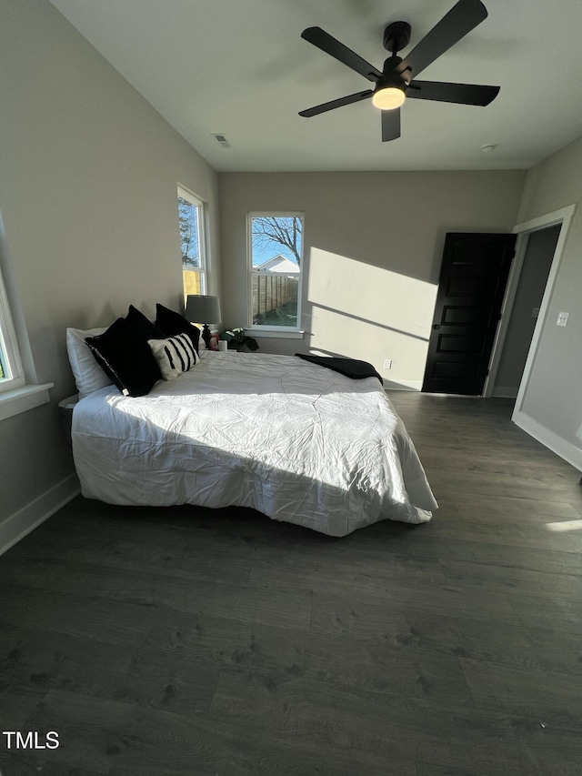 bedroom with visible vents, ceiling fan, baseboards, and wood finished floors