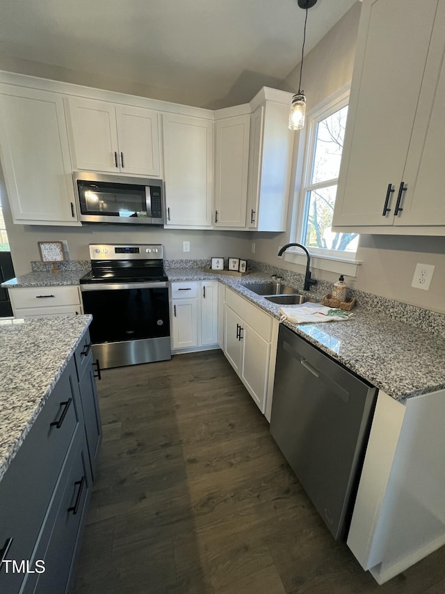 kitchen with stainless steel appliances, dark wood-style flooring, white cabinets, and a sink