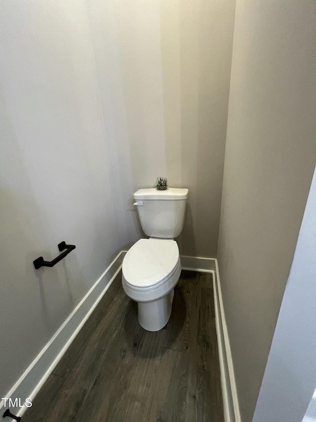 bathroom with baseboards, toilet, and wood finished floors