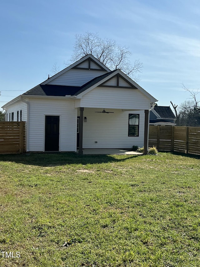 back of house featuring a yard, a patio, a fenced backyard, and a ceiling fan