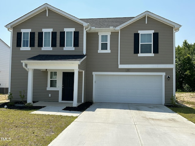 traditional home featuring an attached garage, covered porch, and driveway