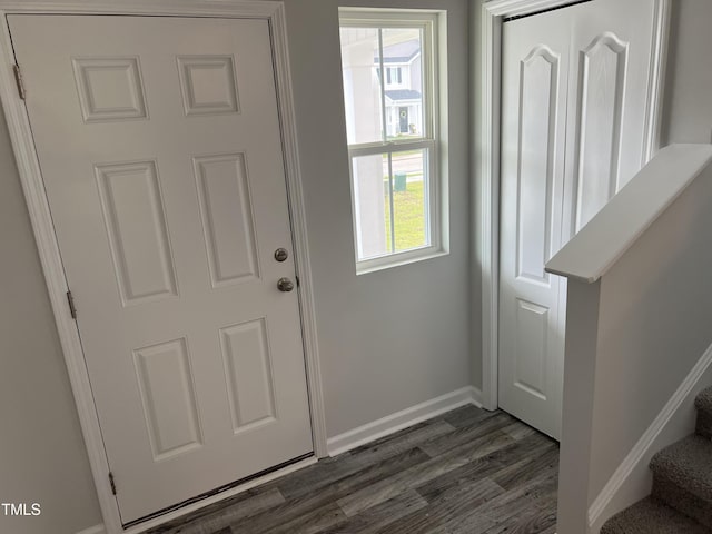 entryway with stairs, dark wood-style floors, and baseboards