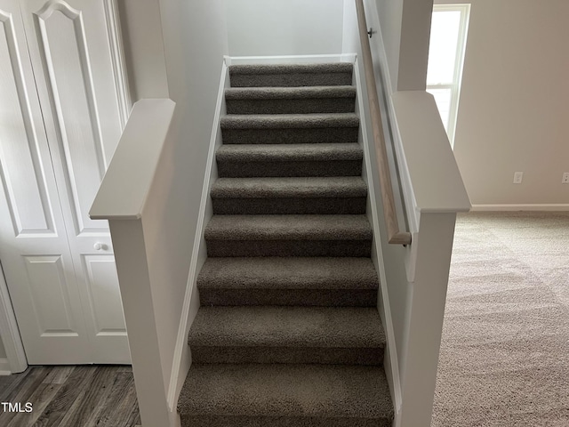 stairway with baseboards and wood finished floors