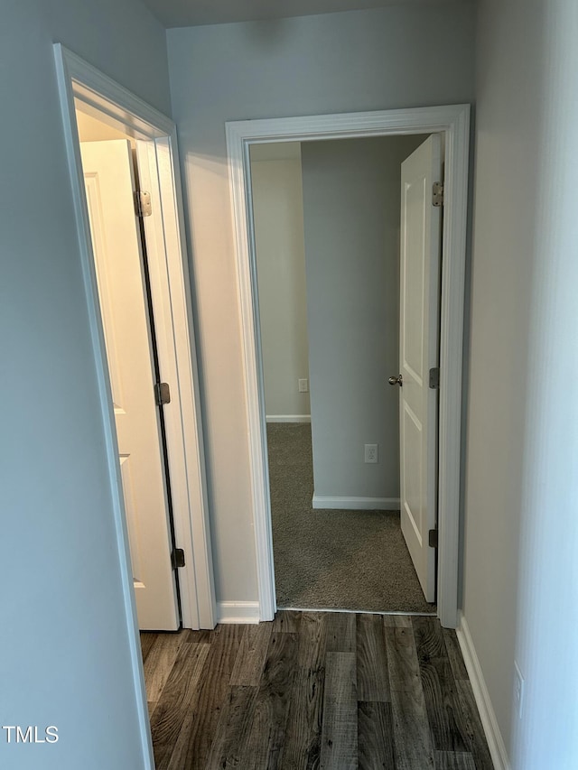 corridor featuring dark wood-style floors and baseboards