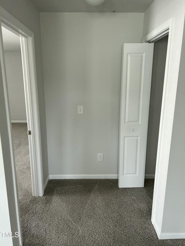 spare room with baseboards and carpet floors