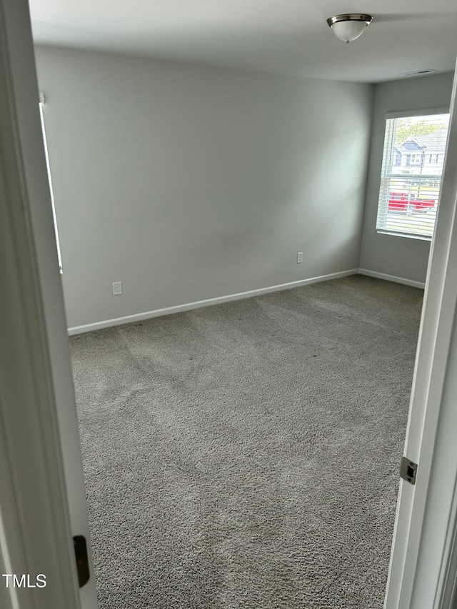 unfurnished room with visible vents, baseboards, and carpet