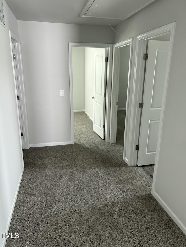 unfurnished room featuring attic access, baseboards, visible vents, and carpet floors