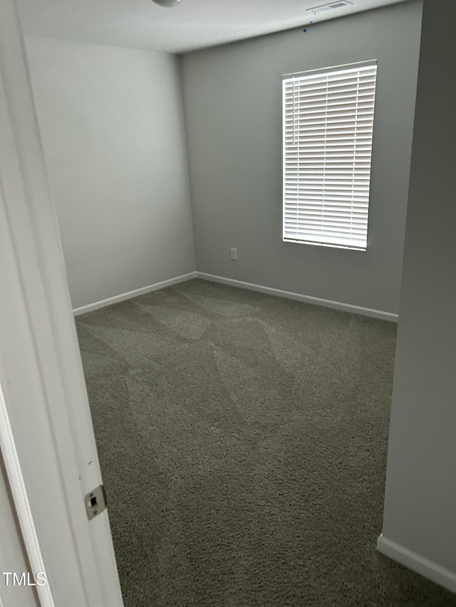 carpeted spare room with visible vents and baseboards