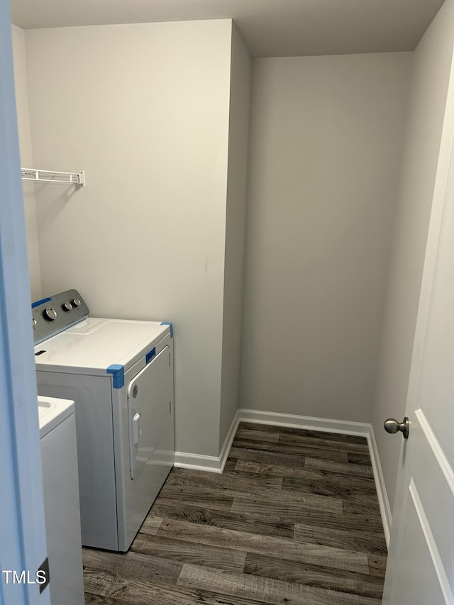 washroom with washer and dryer, baseboards, dark wood-style flooring, and laundry area