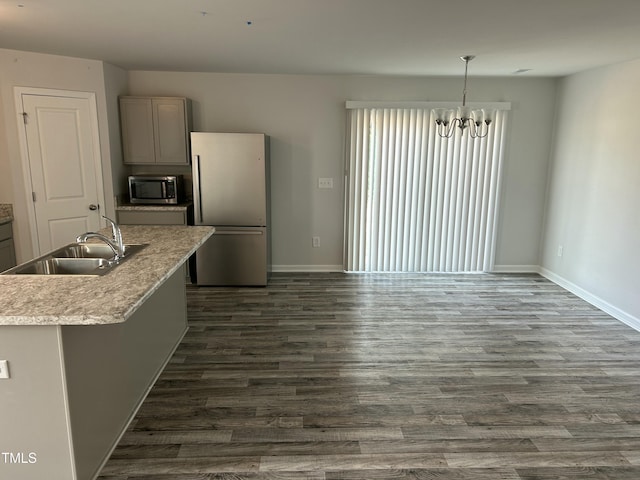 kitchen featuring gray cabinets, a sink, dark wood finished floors, appliances with stainless steel finishes, and baseboards