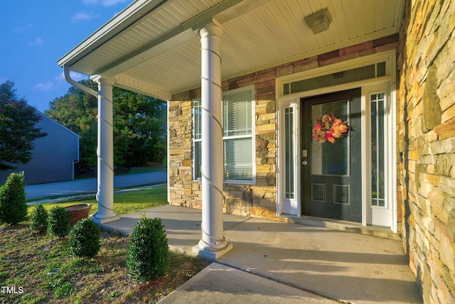 doorway to property with stone siding and a porch