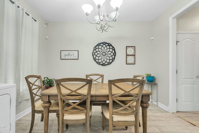 dining area with light wood-type flooring, baseboards, washer / clothes dryer, and a chandelier