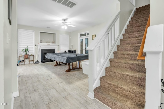 bedroom featuring baseboards, visible vents, ceiling fan, wood finish floors, and a fireplace