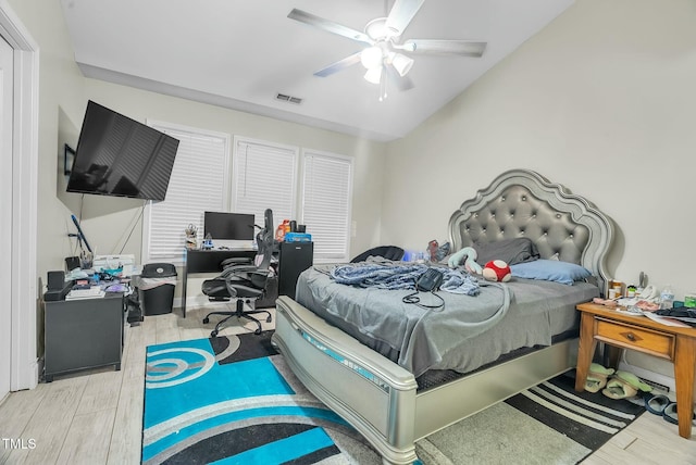 bedroom featuring vaulted ceiling, wood finished floors, visible vents, and a ceiling fan