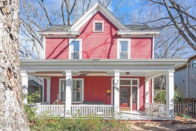 view of front of house featuring a porch and fence