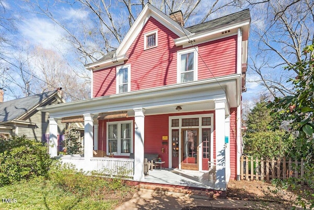 view of front of property featuring covered porch and a chimney