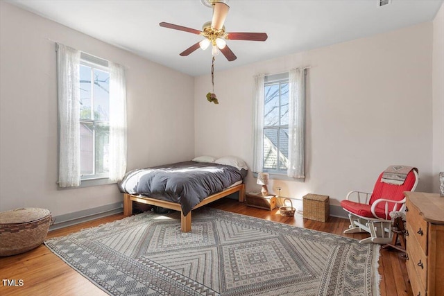 bedroom featuring baseboards, a ceiling fan, and wood finished floors