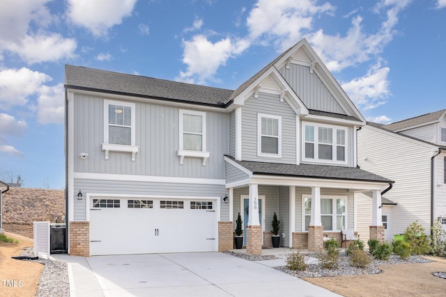 craftsman-style house with driveway, an attached garage, covered porch, board and batten siding, and brick siding