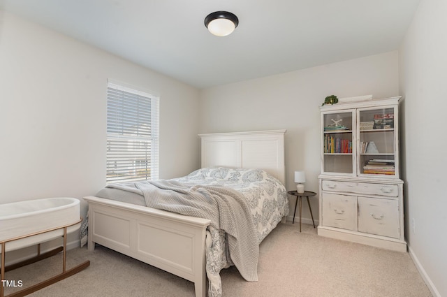 bedroom featuring light colored carpet and baseboards