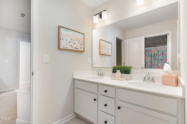 bathroom featuring double vanity, baseboards, visible vents, and a sink