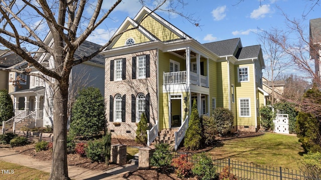 view of front of house with a shingled roof, fence, a front yard, a balcony, and crawl space