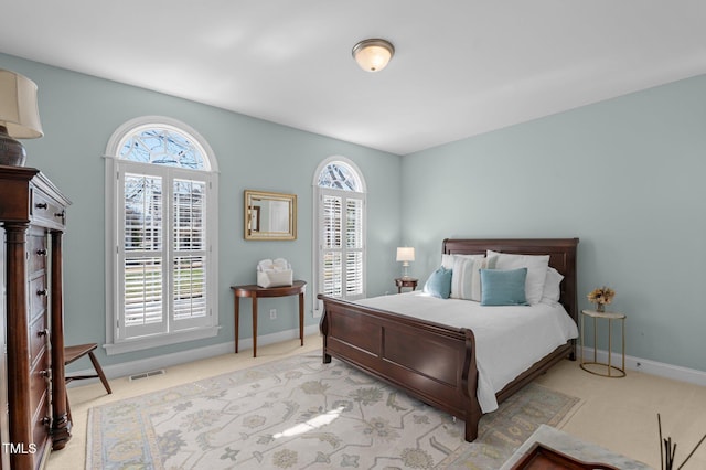 bedroom with visible vents, carpet flooring, and multiple windows