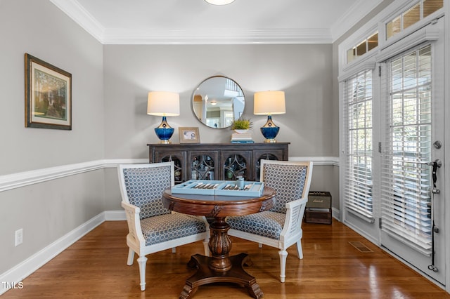 dining area featuring visible vents, crown molding, baseboards, and wood finished floors