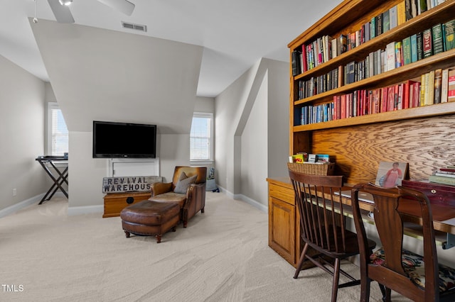 office featuring visible vents, light carpet, baseboards, and a ceiling fan