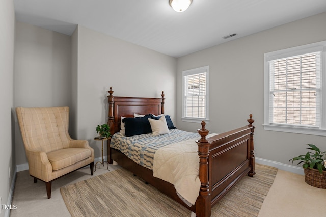 bedroom with light carpet, visible vents, and baseboards