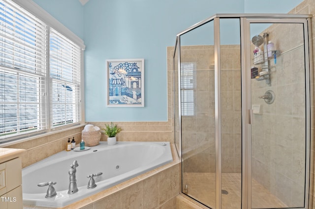 full bath featuring plenty of natural light, a jetted tub, and a stall shower