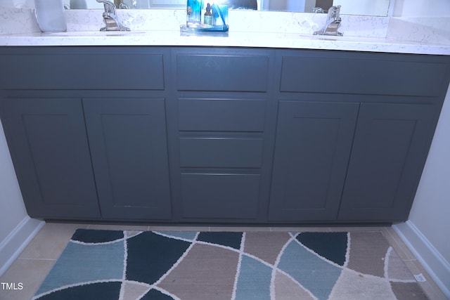 bathroom featuring tile patterned flooring, a sink, and double vanity