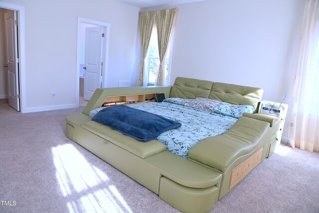 bedroom with carpet floors, connected bathroom, and baseboards