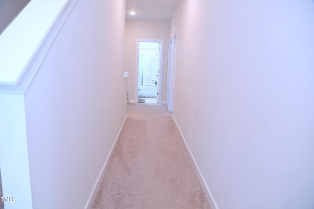 hallway with recessed lighting, light carpet, and baseboards