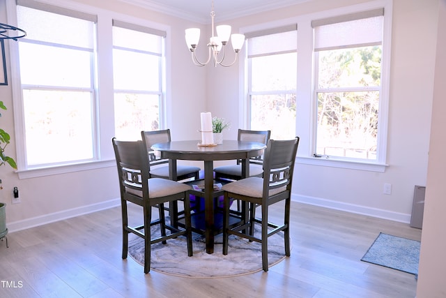 dining area featuring a notable chandelier, plenty of natural light, light wood-type flooring, and crown molding