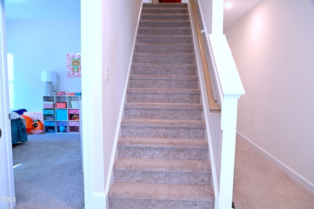 stairway with baseboards and carpet flooring