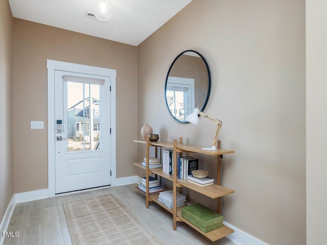 entryway featuring visible vents, baseboards, and wood finished floors