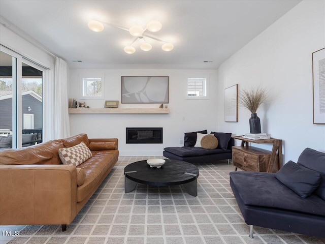 living area featuring a glass covered fireplace and visible vents
