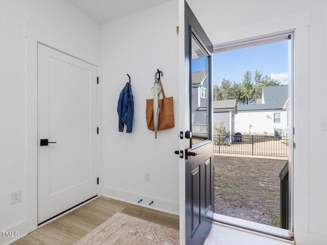 doorway to outside featuring wood finished floors and baseboards