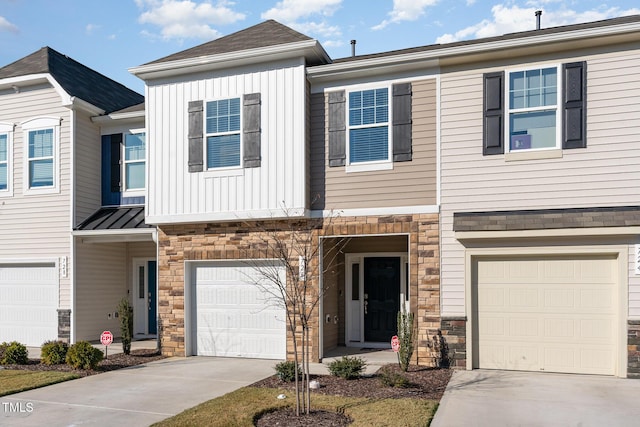 view of property with driveway, stone siding, an attached garage, and board and batten siding