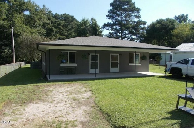 view of front of home with a shingled roof, a front yard, and fence