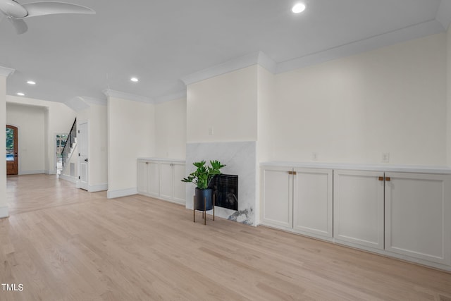 empty room with stairway, a fireplace, light wood-style flooring, and recessed lighting