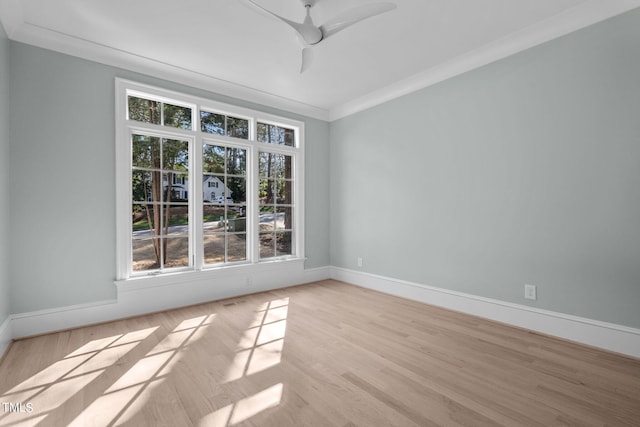 spare room featuring crown molding, ceiling fan, baseboards, and light wood-style floors