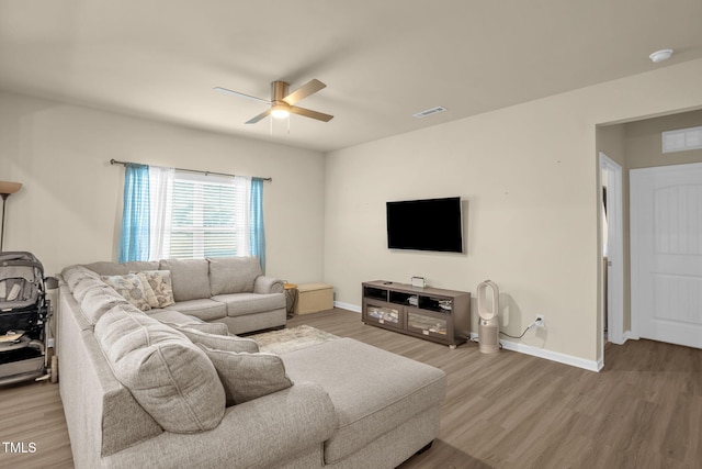 living room with visible vents, baseboards, ceiling fan, and wood finished floors