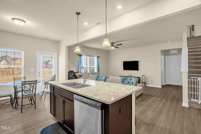 kitchen featuring visible vents, dark brown cabinets, light wood-type flooring, stainless steel dishwasher, and a sink