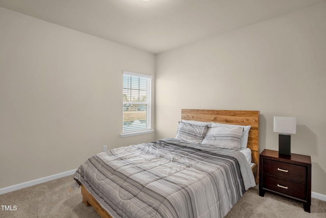 bedroom featuring baseboards and light colored carpet