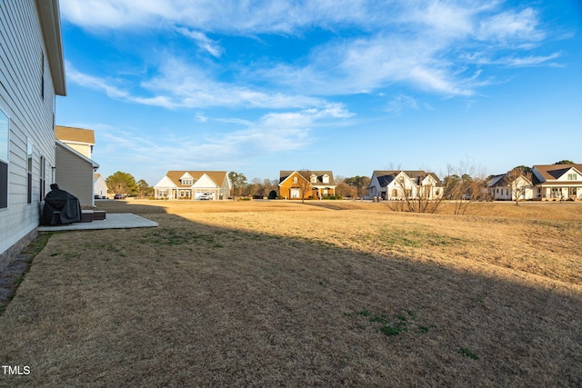 view of yard with a residential view and a patio area