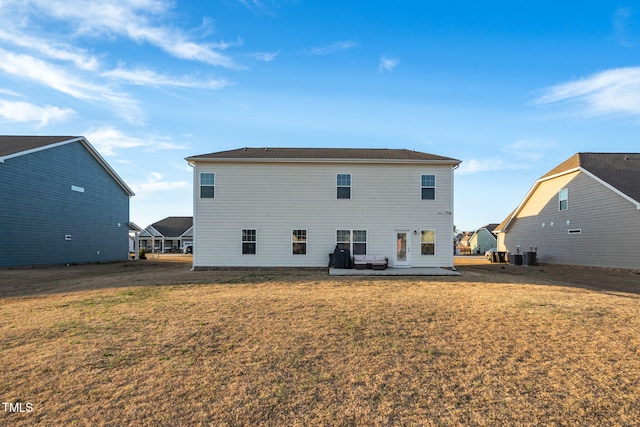 back of property with a lawn, central AC unit, and a patio