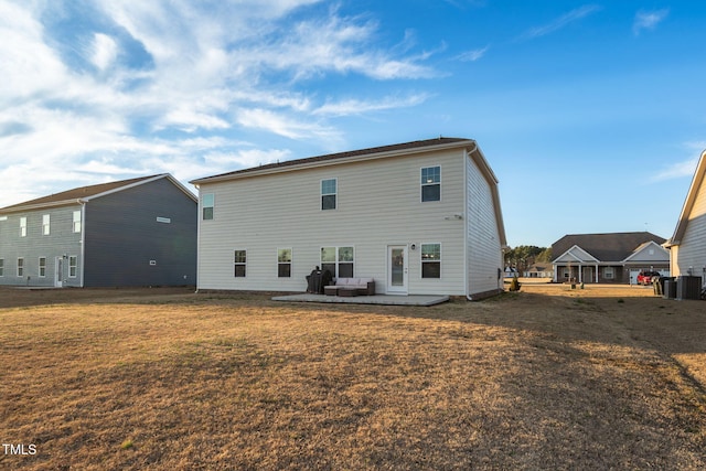 rear view of house with a lawn and a patio